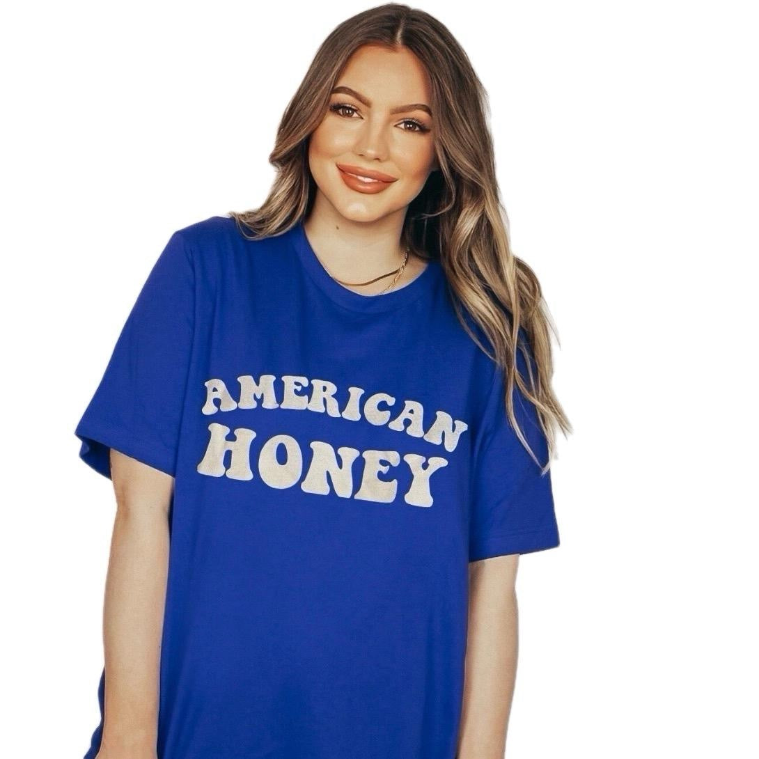 Woman wearing royal blue oversized graphic tee with ‘American Honey’ text – casual summer fashion